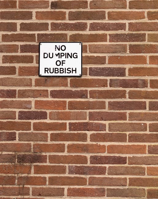 A crumpled plastic bag made from lightweight, glossy material with a predominantly blue and white design rests on a concrete curb, partially folded over with some loose edges visible. The bag appears 